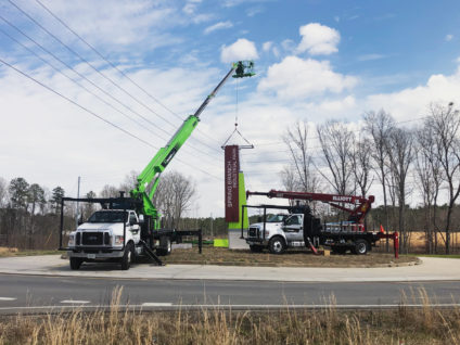 Two Ortwein Sign cranes installing sign in Cleveland TN in Traffic Circle