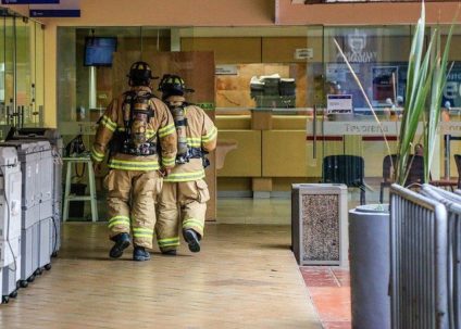 Two firefighters walking away in a building