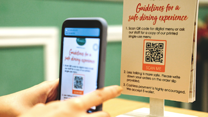 Close-up of person holding a phone scanning a QR code