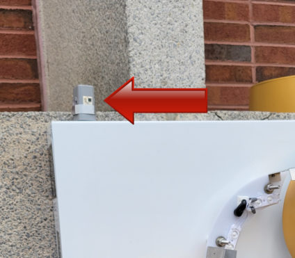 Photocell on a sign with arrow pointing to it