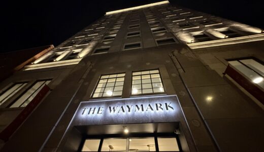 Custom entryway signage fabricated by Ortwein Sign as seen in a night photo of the facade of The Waymark hotel in downtown Chattanooga lit up at night