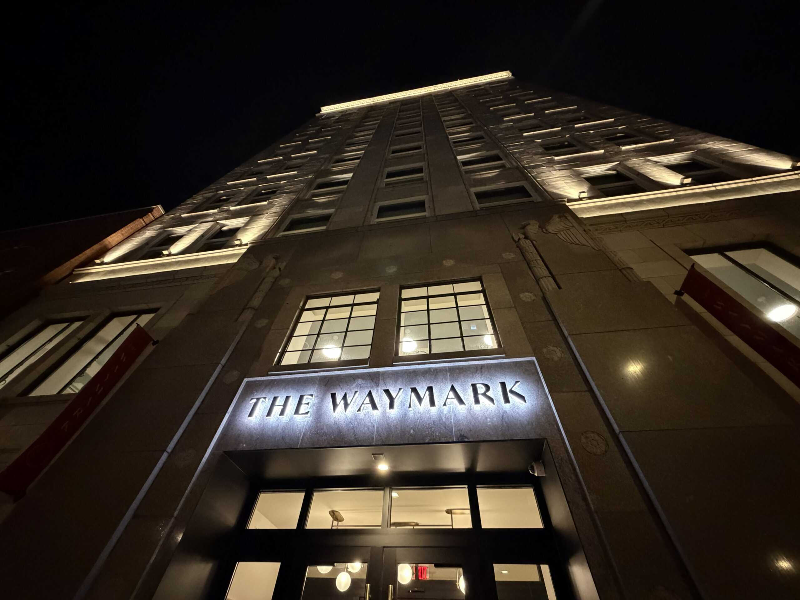Custom entryway signage fabricated by Ortwein Sign as seen in a night photo of the facade of The Waymark hotel in downtown Chattanooga lit up at night