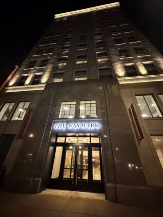 The Waymark in downtown Chattanooga's facade with the entry sign lit up at night